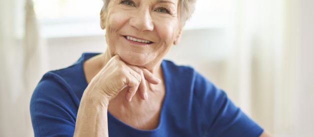 Smiling grandmother sitting at the table